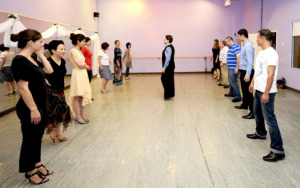 Ballroom dance instructor leading a group class at Dancingland Dance Studio. Students practicing dance steps in a structured and engaging learning environment.