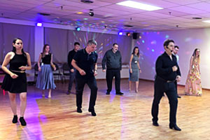 Group dance class at Dancingland Dance Studio with students practicing steps under colorful lights. A fun and energetic ballroom and Latin dance session in a welcoming environment.