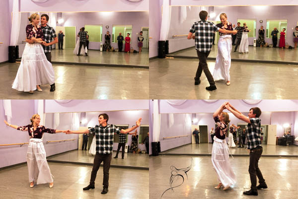 Couple dancing at a Dancingland Dance Studio social event, elegantly performing a ballroom dance routine with an audience in the background.